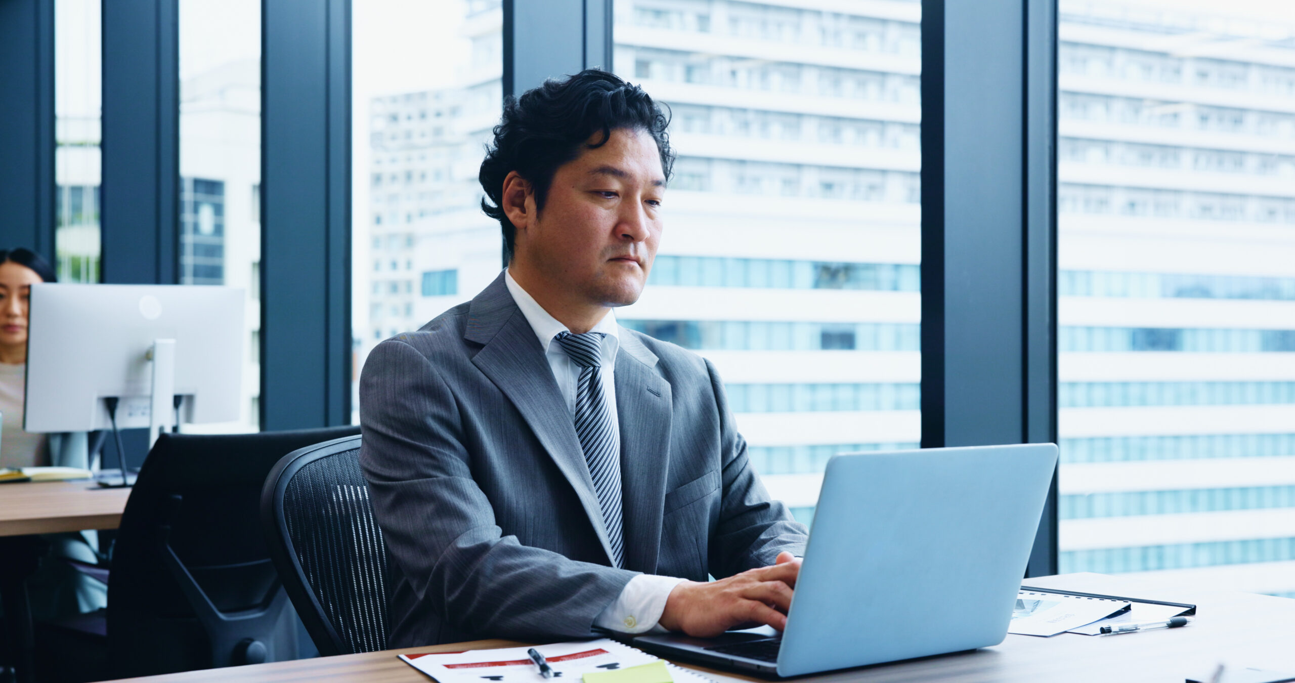 male banker working on a computer focused on financial close task management